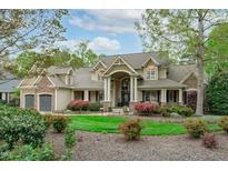 Inviting two-story home with manicured lawn, lush landscaping, and welcoming front porch at 2922 Bells Pointe Ct, Apex, NC 27539
