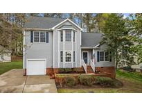 Charming two-story home with gray siding, a well-manicured lawn, and an inviting front entrance at 301 Tillamook Dr, Wake Forest, NC 27587