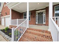 Charming brick home featuring a welcoming front porch with white railing and columns at 3729 Norman Blalock Rd, Willow Springs, NC 27592