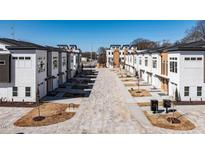 Eye-level view of new construction townhomes with brick-paved entrance driveways and manicured landscaping at 620 Walnut Heights Dr # 101, Raleigh, NC 27610
