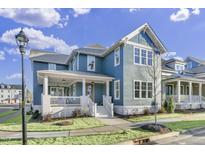 Charming blue two-story home with a welcoming front porch and beautifully landscaped yard at 818 St Charles St, Durham, NC 27713