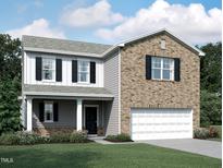 Charming two-story home featuring brick and siding with a well-manicured lawn at 841 Kenyon Spring Dr, Zebulon, NC 27597