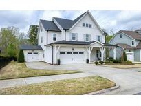 Charming white two-story home with a large driveway and a detached garage at 853 Rambling Oaks Ln, Holly Springs, NC 27540