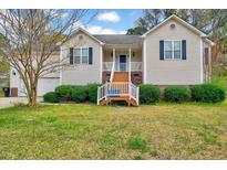 Charming home featuring a well-manicured lawn, complemented by a welcoming front porch and two-car garage at 91 Buckingham Ct, Smithfield, NC 27577