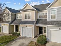 Charming townhouse boasts a one-car garage, manicured lawn, and classic architectural details, creating an inviting curb appeal at 10133 Bessborough Dr, Raleigh, NC 27617