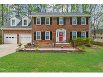 Charming brick home with a two-car garage, dormer windows, and a vibrant red front door at 114 Oxpens Rd, Cary, NC 27513