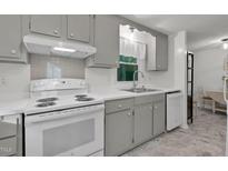 Bright kitchen features white appliances, gray cabinets, and updated counters at 1332 Stallings Rd, Chapel Hill, NC 27516