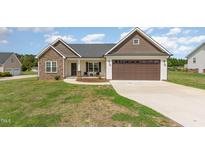 Charming single-story home with stone accents, brown garage door, and well-maintained lawn at 158 Blande Dr, Kenly, NC 27542