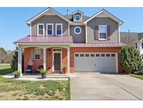 Charming two-story home features brick accents, a two-car garage, covered porch, and a well-maintained lawn at 192 Solheim Ln, Raleigh, NC 27603