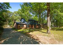 Charming two-story home with brick accents, blue siding, mature trees and a long concrete driveway at 204 N Gurney St, Burlington, NC 27215