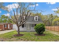 Charming home featuring a well-maintained front yard with mature trees, a picket fence, and inviting curb appeal at 226 1St St, Henderson, NC 27536