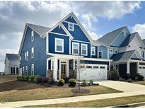 Beautiful two-story home with blue siding, stone accents, and a two-car garage at 2265 Kettle Falls Sta, Apex, NC 27502