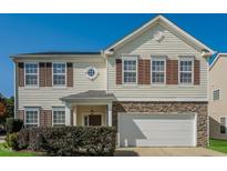 Charming two-story home featuring brown shutters, stone accents and a white garage door at 2321 Stony Bottom Dr, Raleigh, NC 27610