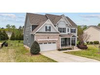 Charming two-story home featuring a brick and siding exterior, attached garage, and well-manicured landscaping at 265 Beckwith Ave, Clayton, NC 27527