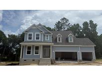 Charming two-story home featuring light blue siding, white trim, and an attached two-car garage at 426 Adams Pointe Ct, Angier, NC 27501