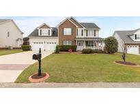 Charming two-story home with a brick and vinyl facade, well-manicured lawn, and inviting curb appeal at 43 Summerseat Way, Bunnlevel, NC 28323