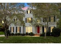 Charming two-story home boasts a manicured lawn, a bright red front door, and classic black shutters at 4313 Branchwood Dr, Durham, NC 27705
