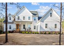 Beautiful white farmhouse with board and batten siding and a welcoming front porch at 494 Terry Rd, Hillsborough, NC 27278