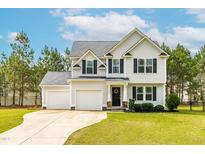 Charming two-story home with a manicured lawn and a two-car garage, perfect for Gathering living at 5989 Zacks Mill Rd, Angier, NC 27501