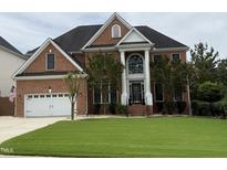 Beautiful red brick home with manicured lawn, attached two car garage and stylish front entrance at 6020 Jones Farm Rd, Wake Forest, NC 27587