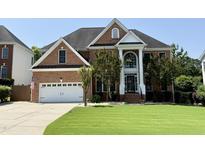 Beautiful brick home with a well-manicured lawn, attached garage, and grand entrance with columns at 6020 Jones Farm Rd, Wake Forest, NC 27587