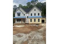 Two-story home with a dark roof, light siding, and visible construction materials in the yard at 70 Valebrook Ct, Youngsville, NC 27596