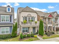 Charming two-story townhouse with a balcony, well-manicured lawn, and cozy front porch at 989 Ambergate Sta, Apex, NC 27502