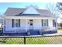 Charming home featuring a covered front porch, white siding, and a well-maintained lawn at 10095 N Walnut St St, Middlesex, NC 27557