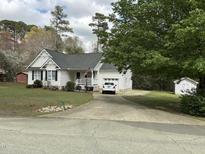 Charming one-story home with white siding, black shutters, covered front porch, and an attached garage at 103 Kiowa Cv, Louisburg, NC 27549