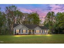 Charming single-story home with a well-manicured lawn and mature trees in a peaceful neighborhood at twilight at 1117 Country Brooke Dr, Raleigh, NC 27603