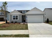 Charming single-story home featuring a manicured lawn and a two-car garage at 163 Little Creek Dr, Lillington, NC 27546