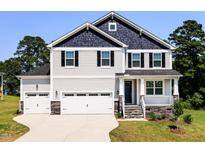 Charming two-story home with a three-car garage, welcoming porch, and well-maintained lawn at 176 Golfview Ave, Benson, NC 27504
