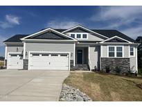 Charming home featuring a three-car garage, stone accents, and attractive gray siding under a blue sky at 196 Golfview Ave, Benson, NC 27504