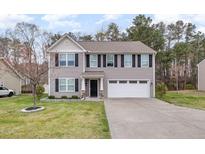 Charming two-story home featuring a well-maintained lawn and a two-car garage at 211 Richmond Run, Stem, NC 27581