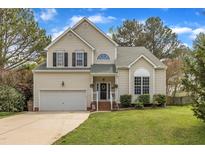 Charming two-story home featuring a well-manicured lawn, attached garage, and inviting front porch at 2832 Steeple Run Dr, Wake Forest, NC 27587