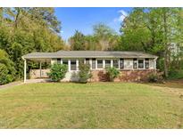 Charming one-story home with a brick base, gray siding, and a covered carport at 3332 Apache Dr, Raleigh, NC 27609