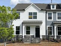 Charming two-story home with white siding, black trim, and a small front yard behind a black metal fence at 486 Traditions Grande Blvd # 28, Wake Forest, NC 27587