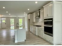 Open-concept kitchen with stainless steel appliances, a large island, and bright natural light at 486 Traditions Grande Blvd # 28, Wake Forest, NC 27587