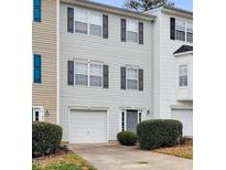 Charming two-story townhouse with a one-car garage, black shutters, and manicured bushes at 5163 Sandy Banks Rd, Raleigh, NC 27616