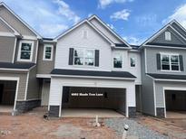 New construction two-story townhome with two-car garage and white siding and black shutters at 6002 Shade Tree Ln, Durham, NC 27703