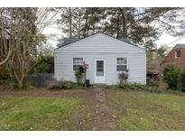 Quaint single-story home with light siding, complemented by a mailbox and surrounded by mature trees at 1203 Brookside Dr, Raleigh, NC 27604