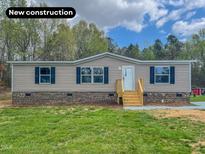 Charming one-story home with new construction and well-manicured lawn and navy-blue shutters at 1326 Stephens Dr, Roxboro, NC 27573
