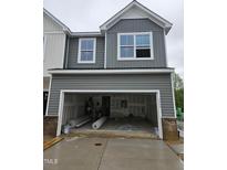 Two-story home featuring an attached garage with grey siding and brick accents at 1344 Bessie Ct, Wake Forest, NC 27587