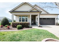 Charming home featuring manicured lawn, flowerbeds, and a two-car garage at 135 Brocks Trce, Burlington, NC 27215