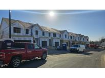 An image of townhomes under construction showing the framing stage and exterior materials being installed with a clear blue sky at 1367 Bessie Ct, Wake Forest, NC 27587