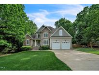 Beautiful stone and siding two-story home with a well-manicured lawn and two-car garage at 1404 Rhea Dr, Garner, NC 27529