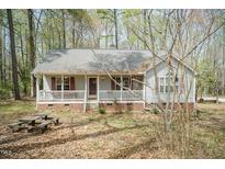 Charming single-story home with a welcoming front porch and mature trees at 1508 Middle Ridge Dr, Willow Springs, NC 27592