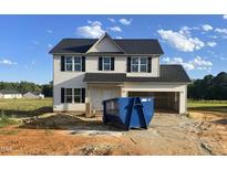 Two-story home featuring vinyl siding, black shutters, and an attached two-car garage at 163 N Movado Trl, Kenly, NC 27542