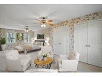 A spacious bedroom features floral wallpaper, hardwood floors, and plentiful natural light through the windows at 167 Coachmans Cove Rd, Four Oaks, NC 27524