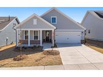 Charming single-story home featuring a covered porch, two-car garage, and well-maintained front yard at 1805 Angelonia Way, Fuquay Varina, NC 27526